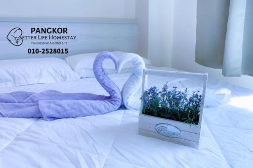 a box with a swan and flowers on a bed at Better Life Apartment near beach-2room 2bathroom 6pax in Pangkor