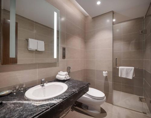 a bathroom with a sink and a toilet and a shower at Luxury Apartment - Rooftop Swimming Pool - Beach Front - Hinata Apartment in Da Nang