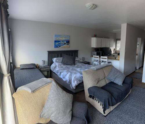 1 dormitorio con cama, sofá y cocina en 5 Bayview Gonubie Seafront, en Gonubie