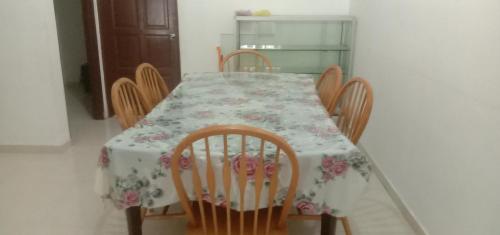 mesa de comedor con sillas y mantel de flores en Homestay Humair, en Marang