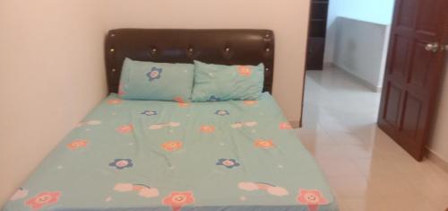 Una cama con un edredón azul con ladillas. en Homestay Humair, en Marang