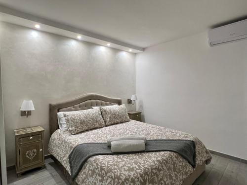 - une chambre avec un grand lit et 2 tables de chevet dans l'établissement Gaiola sea house Posillipo, à Naples