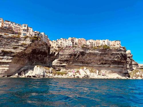 a view from the water of a cliff with buildings at Superbe studio climatisé parking gratuit sur place in Bonifacio