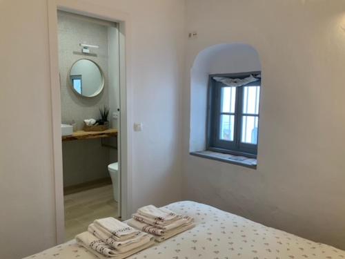 baño con toallas en la cama y espejo en Atico Atlantico con Aparcamiento privado, en Vejer de la Frontera