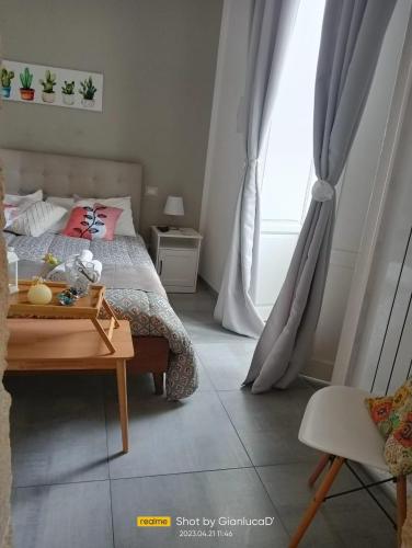 a bedroom with a bed and a table and a window at Sapore di Sale - Sicily Rooms in Siracusa