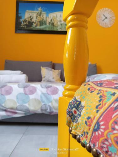 a yellow pole in a room with a bed at Sapore di Sale - Sicily Rooms in Siracusa