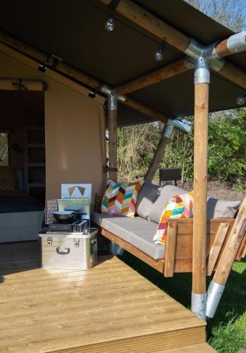 a bed under a gazebo on a deck at Safaritent Lodge 2 plus in Ruurlo