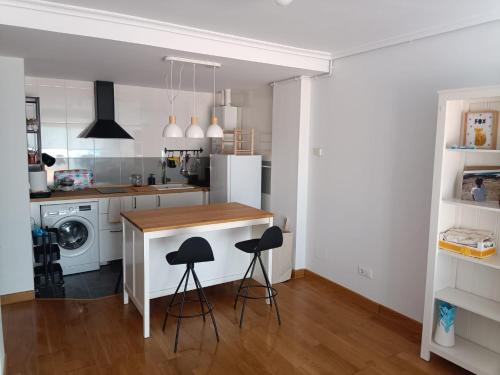 a kitchen with a counter and stools in it at Apartamento con terraza in Comillas