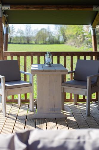 a table and two chairs on a deck at Safaritent Lodge 2 plus in Ruurlo