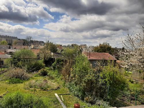 une vue d'une cour avec des buissons et des maisons dans l'établissement LISBONNE, au Mans