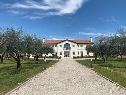 a large white house with a pathway leading to it at Agriturismo Zapparè Farm Hotel in Trevignano