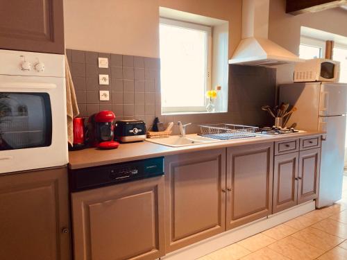 a kitchen with a sink and a microwave at L'Adéenne in Gondrin
