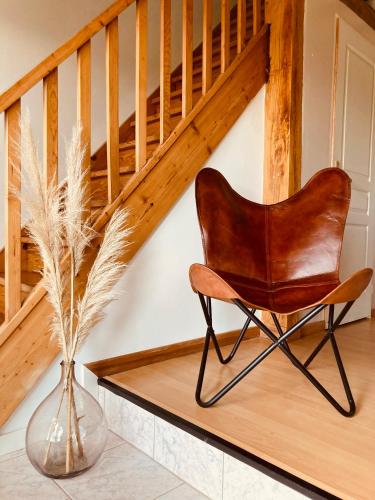 a chair in a vase next to a staircase at L'Adéenne in Gondrin