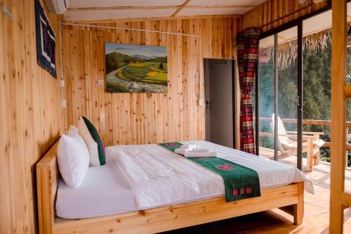 um quarto com uma cama num quarto de madeira em Le Chalet Homestay em Bac Hà