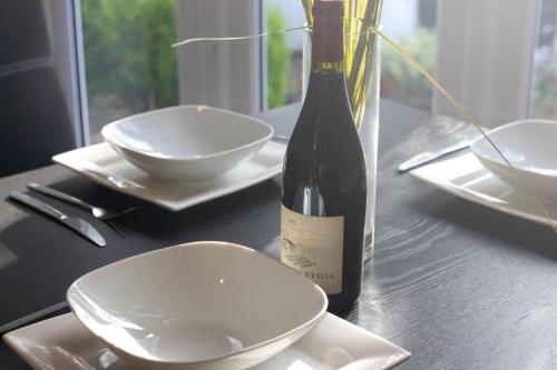 una botella de vino sentada en una mesa con platos en Dunkirk House, en Southampton