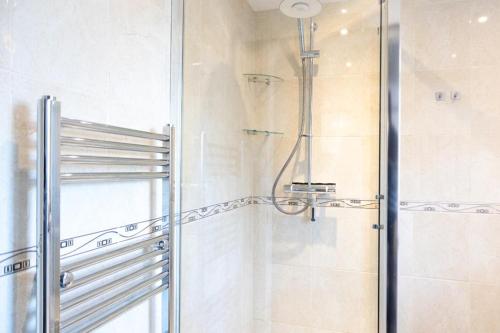 una doccia con porta in vetro in bagno di Dunkirk House a Southampton