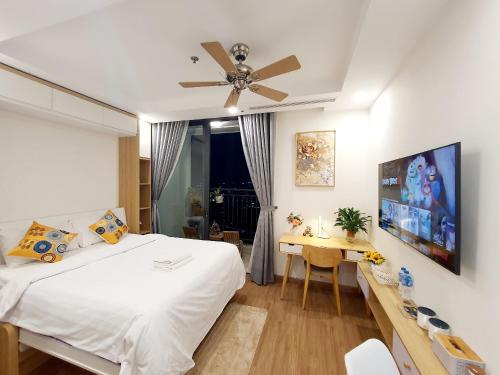 a bedroom with a bed and a desk and a ceiling fan at Studio Lake view Vinhomes Greenbay #Jerry's House in Hanoi