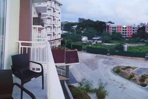 a balcony with a chair and a view of a building at Amani Grand Residence near Mactan Cebu Intl Airport in Mactan