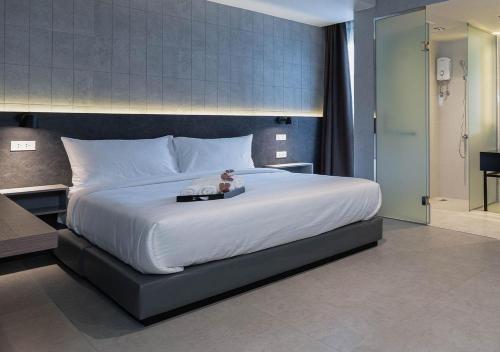 a bedroom with a large bed with a teddy bear on it at EX2 Hotel in Ban Bang Khen (1)