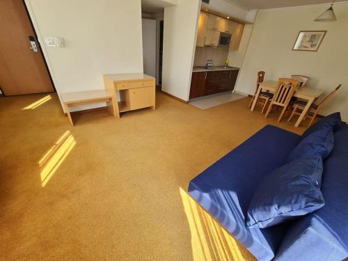 華沙的住宿－10Q - Z6 Apartment 601，一间带蓝色沙发的客厅和一间厨房