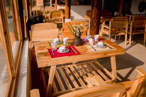 una mesa de madera con un jarrón de flores. en Le Chalet Homestay en Bắc Hà