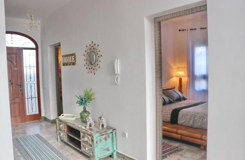1 dormitorio con cama, mesa y espejo en Casa Aqua, en El Guijo