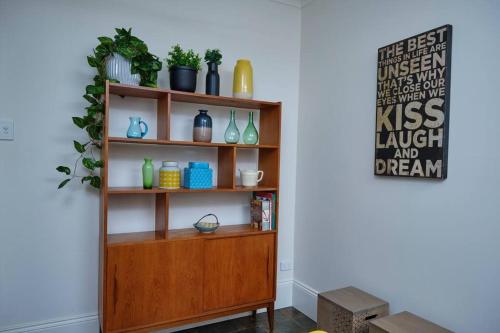 ein Bücherregal mit Vasen und Pflanzen darauf in der Unterkunft Short Walk to The Parade and Norwood Oval in Kensington and Norwood