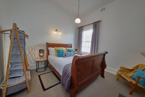 ein Schlafzimmer mit einem Bett, einer Leiter und einem Fenster in der Unterkunft Short Walk to The Parade and Norwood Oval in Kensington and Norwood