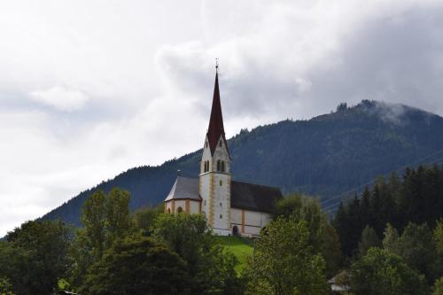 a church with a steeple on top of a hill at Ferienhaus Oberhuben in Fügenberg