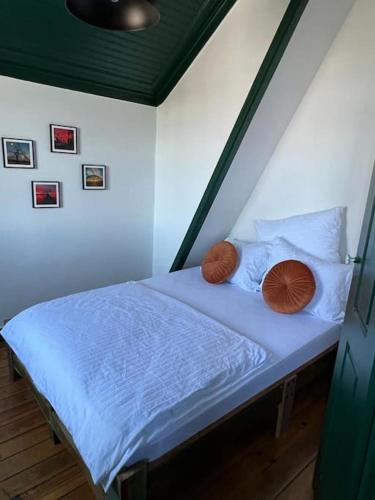 a bedroom with a bed with two pillows and avertisement at Jugendstil Villa - 2 min zum Meer in Figueira da Foz