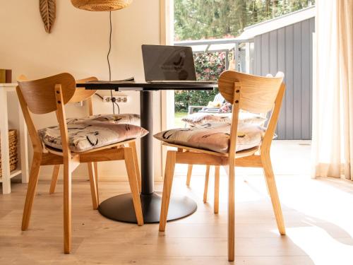 dwa krzesła i biurko z komputerem w obiekcie Stayatsas Tiny House Julia in de bossen op de Veluwe! w mieście Epe