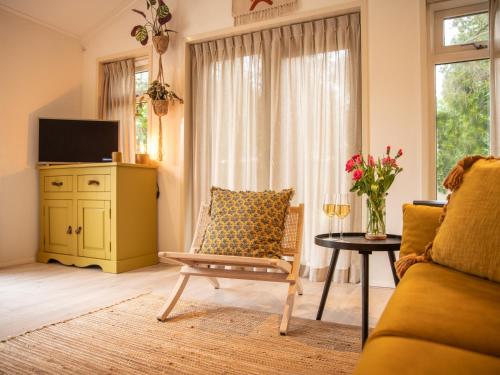 un soggiorno con divano e tavolo di Stayatsas Tiny House Julia in de bossen op de Veluwe! a Epe