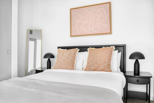 une chambre avec un grand lit blanc avec des oreillers orange dans l'établissement First Hill 1BR w Gym Coworking SEA-453, à Seattle