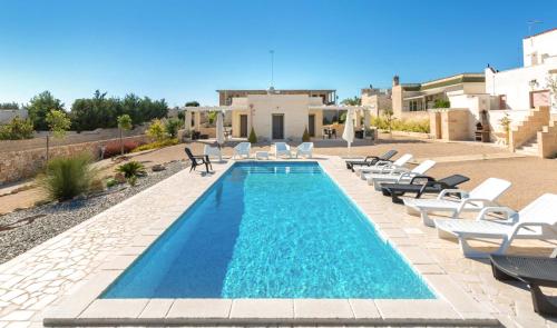 a swimming pool with lounge chairs and a villa at Villa Tina Maria by BarbarHouse in San Pietro in Bevagna