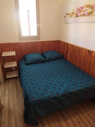 - une chambre avec un lit bleu dans l'établissement Appartement vue mer Le Barcarès, au Barcarès