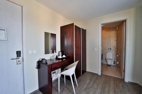 a room with a desk with a chair and a bathroom at Quaint Boutique Hotel Nadur in Nadur