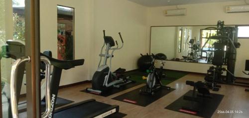 a gym with several exercise bikes and a mirror at Baan Suan Villas Resort in Ban Suan
