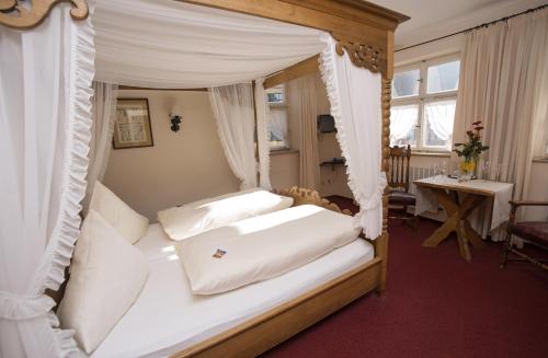 a bedroom with a canopy bed with white pillows at Hotel Eisenkrug in Dinkelsbühl