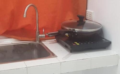 a pot sitting on top of a stove next to a sink at PORTSIDE STUDIOS in Manila