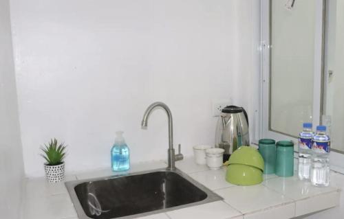 a kitchen counter with a sink and a mirror at PORTSIDE STUDIOS in Manila