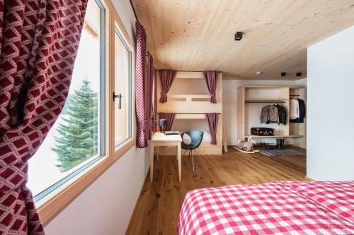 a bedroom with a bed and a large window at Gähwindehof Mountain Ranch Resort in Oberstaufen