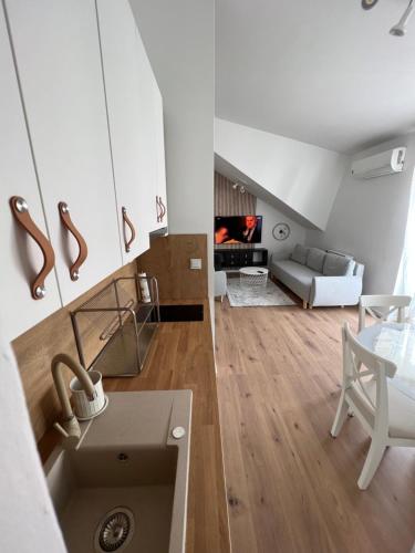 a kitchen with a sink and a living room with a couch at Urban Cozy Apartments Zagreb in Zagreb