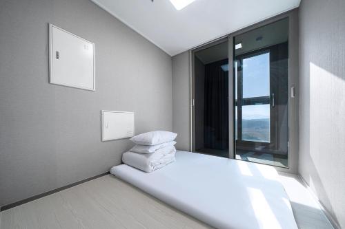 a room with a pile of pillows sitting on the floor at Gangneung Chonpines Ocean Suites Hotel in Gangneung