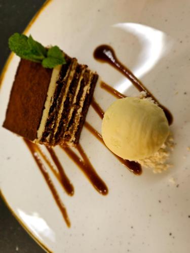 a white plate with a piece of cake and ice cream at Beech Hill Hotel & Spa in Windermere