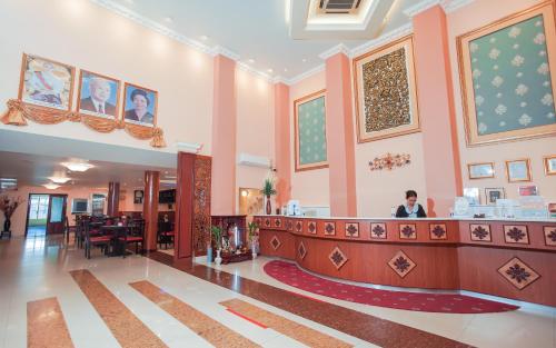 a woman standing at a counter in a lobby at Silver Mounts Hotel in Phnom Penh