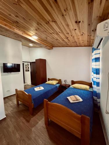 a room with two beds and a tv in it at Old Town - Guest House in Stari Bar