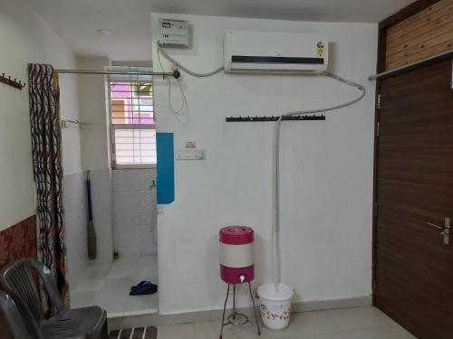 een kamer met een witte muur en airconditioning bij Saar Homestay in Ujjain
