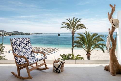 a room with a chair and a view of the beach at Zel Mallorca in Palmanova