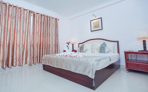 a bedroom with a large bed and a red dresser at Silver Mounts Hotel in Phnom Penh