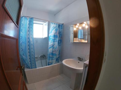 a bathroom with a sink and a toilet and a mirror at KOS Family House in Psalidi